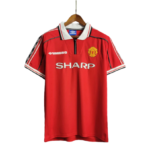Manchester United red home jersey on a hanger with white collar and SHARP sponsor logo across the chest, crest on the left.