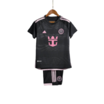 Black soccer kit with pink accents (jersey and shorts) hanging on a wooden hanger; pink crest and stripes visible on the chest and legs.