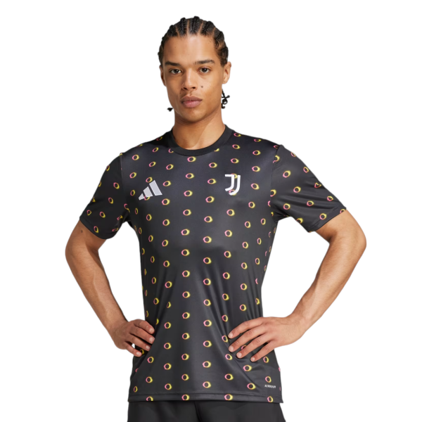 Man wearing a black Juventus training jersey with a yellow-pink donut pattern, standing with hands on hips (logos: Adidas and Juventus crest)