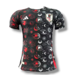 Black Japan national team jersey with red and white celestial patterns and crest on chest.