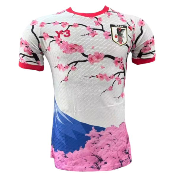 Japan national soccer jersey with pink cherry blossoms, red trim, and crest on the chest.