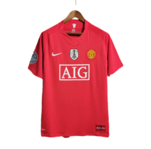 Red Manchester United soccer jersey on a hanger featuring the AIG sponsor logo and team crest, with league patches on the sleeves.