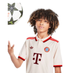 Young person wearing a cream Bayern Munich soccer jersey with red trim, reaching toward a ball hovering on the left side.