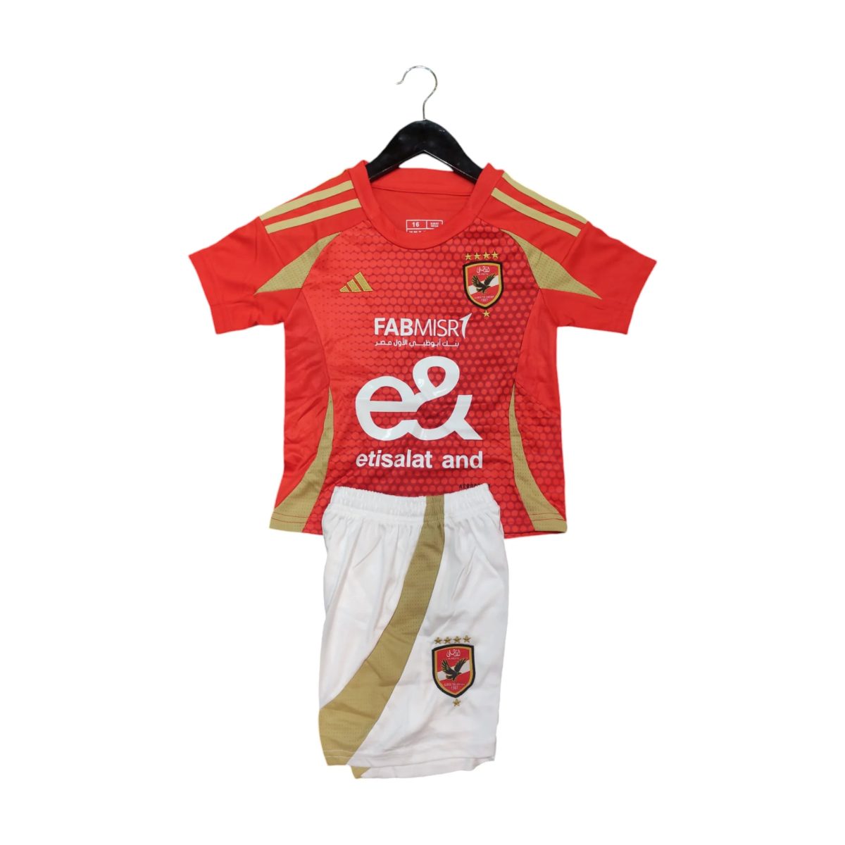 Red football jersey on a hanger with gold trim, crest, and sponsor text (Etisalat) visible on the chest area, paired with white shorts below.