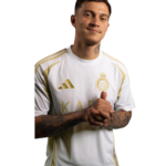 Young man with short dark hair and tattoos wearing a white and gold soccer jersey, hands clasped and smiling.