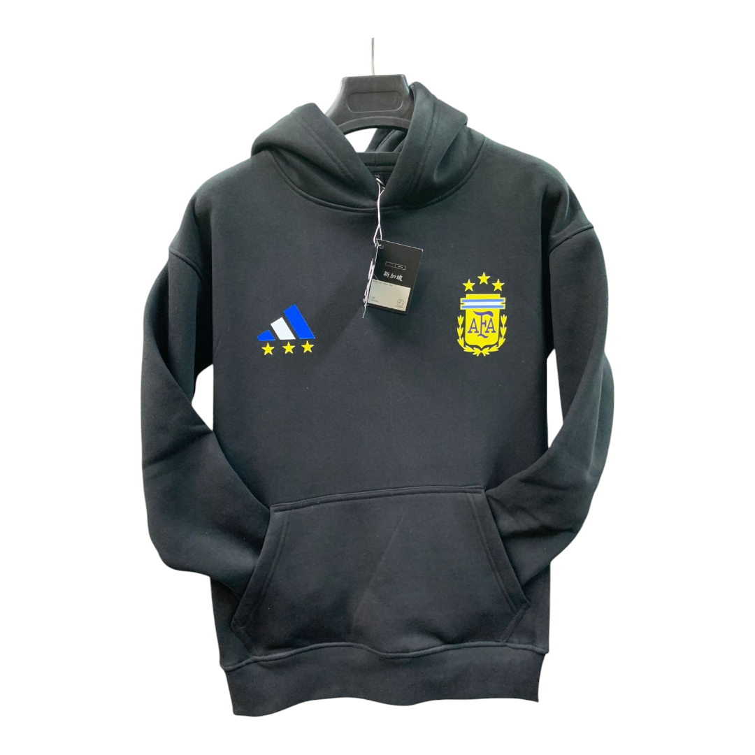 Photoroom-20250110-194252 Black hoodie on a hanger featuring a blue Adidas logo with yellow stars on the left chest and the yellow Argentina Football Association crest on the right chest.