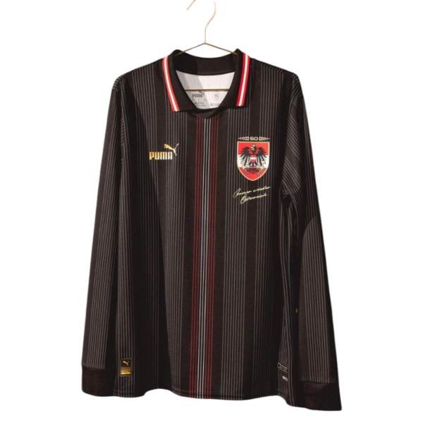 Black pinstriped soccer jersey with red-white collar hanging on a hanger, featuring a crest on the left chest and a yellow Puma logo on the right shoulder area.