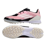 Side view of pink and black soccer cleat with white midsole and studded outsole, designed for traction on firm ground.