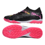 Pair of black textured soccer cleats with bright pink outsole and white midsole, shown from side and bottom views; pink laces and graffiti-style pink branding on the side.