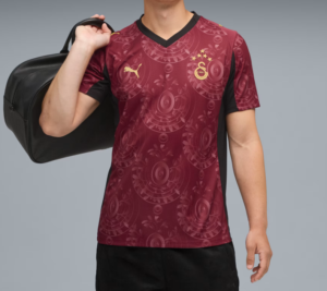 Q1 | UAE SPORT STORE Person wearing a maroon Galatasaray football jersey with crest and Puma logo, carrying a black gym bag over the shoulder.