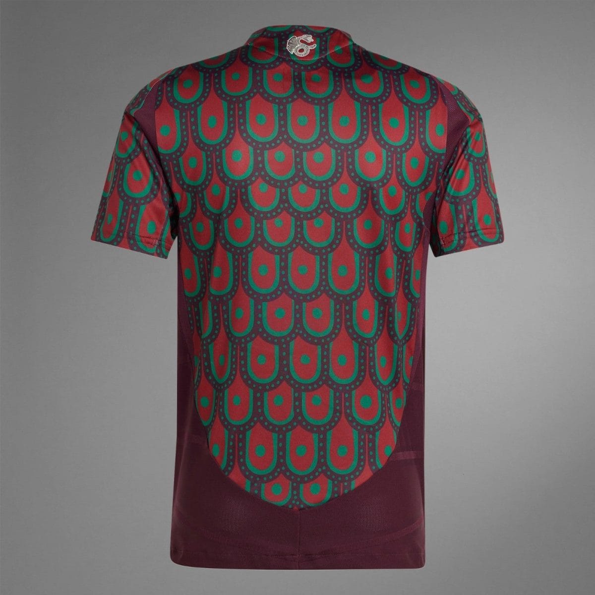 Back view of a maroon shirt with a teal and green repeated scalloped pattern across the fabric.
