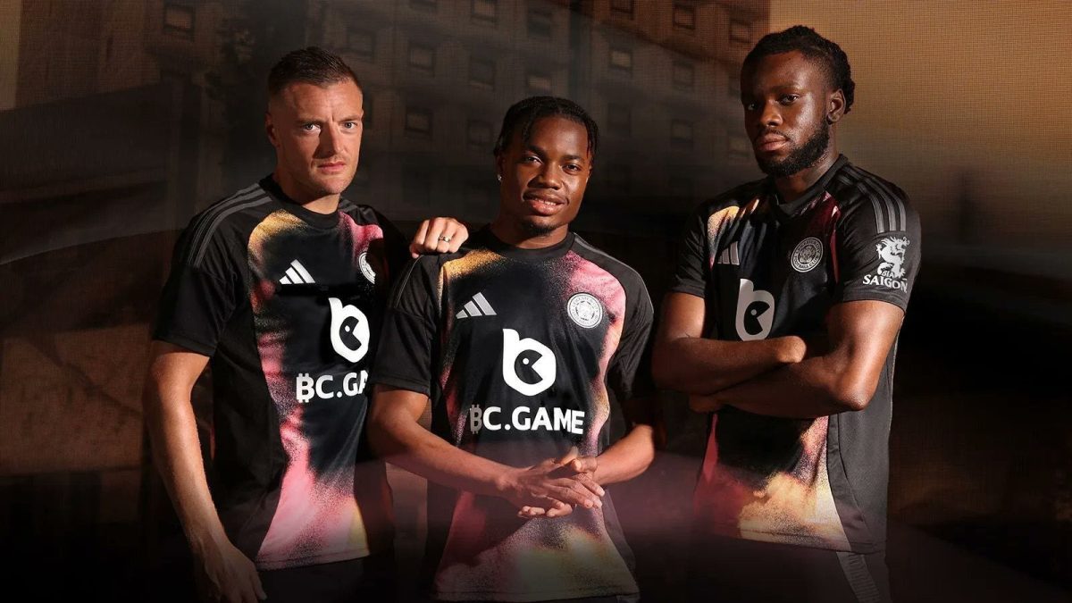 Three male esports players in matching BC.GAME jerseys pose together for a team photo, standing confidently with arms crossed or resting.