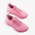 Pair of pink athletic sneakers with rounded chunky soles on a white background