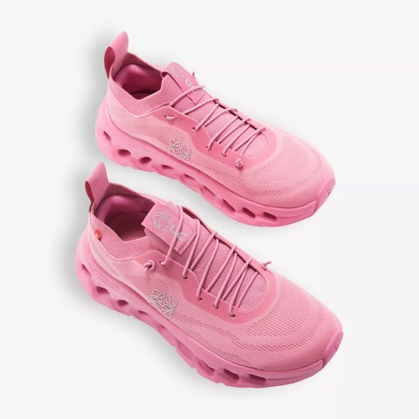 Pair of pink athletic sneakers with rounded chunky soles on a white background