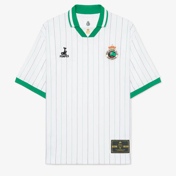White soccer jersey with green collar and cuffs and thin blue vertical pinstripes; features a crest on the left chest and a sponsor logo on the right chest, plus a gold patch near the bottom hem.