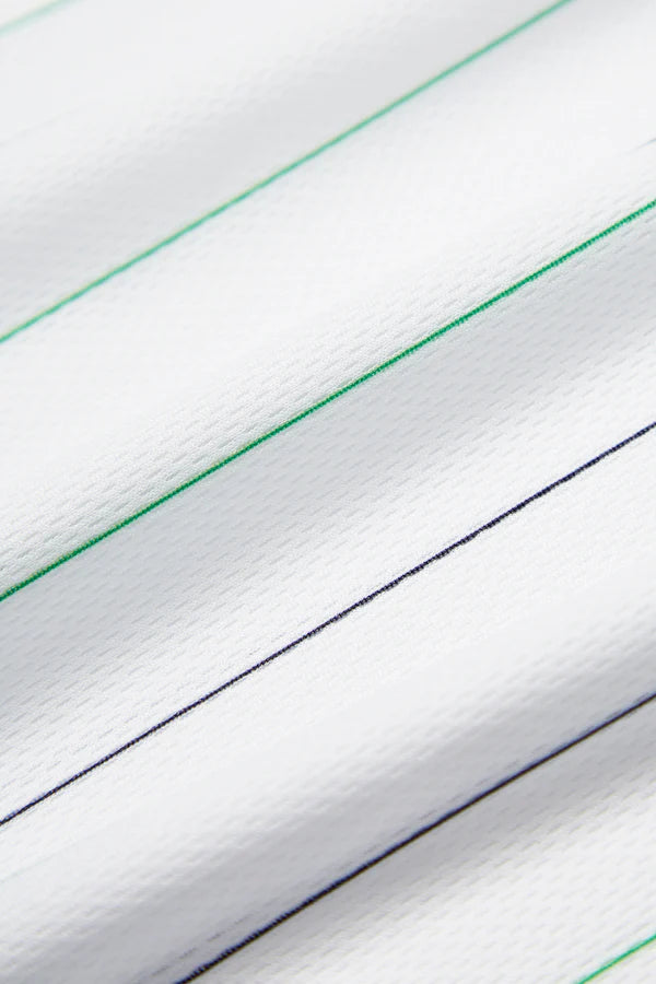 RACINGSHORTSLEEVE_08_600x_6cff56d3-db48-4b71-aace-1a01b23c3102 | UAE SPORT STORE Close-up of white fabric with diagonal green and dark navy striped lines and subtle texture.