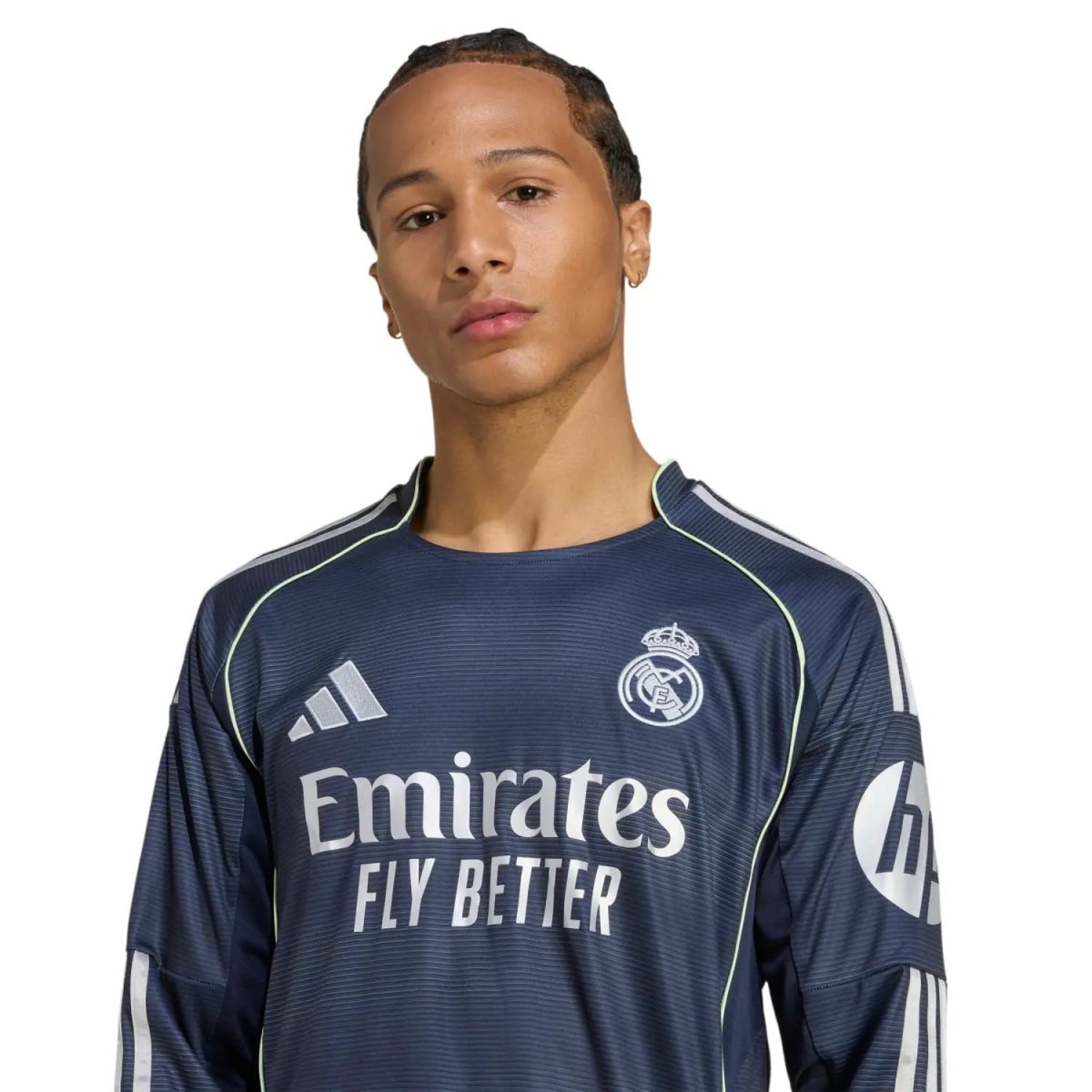 Man wearing a dark Real Madrid football jersey with 'Emirates Fly Better' slogan visible on the front.