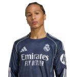 Man wearing a dark Real Madrid football jersey with 'Emirates Fly Better' slogan visible on the front.