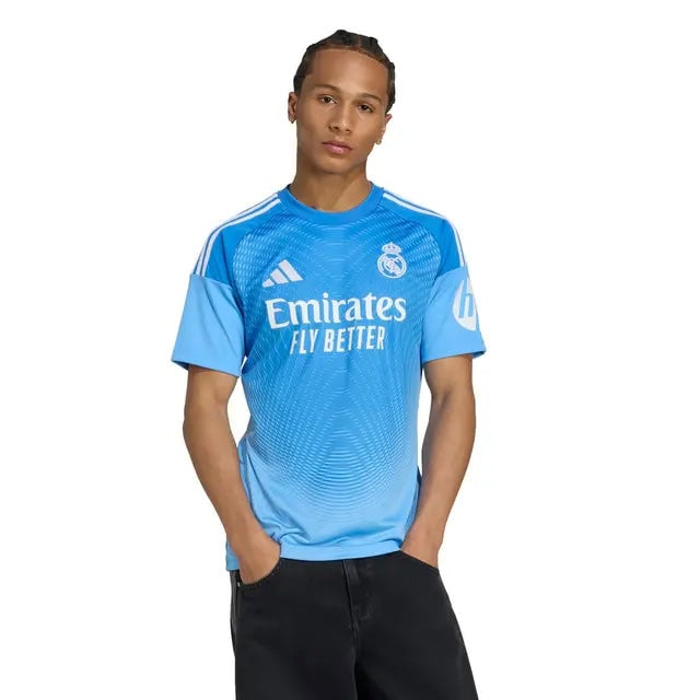RMCFMZ0916_04 | UAE SPORT STORE Man wearing Real Madrid blue away jersey with Emirates sponsor, posing with hands in pockets.