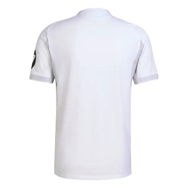 RMCFMZ0919_08 | UAE SPORT STORE White short-sleeve polo shirt shown from the back, featuring a dark circular patch on the left sleeve.