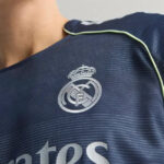 RMCFMZ0920_12 | UAE SPORT STORE Close-up of Real Madrid football jersey with the club crest on navy fabric and light green piping