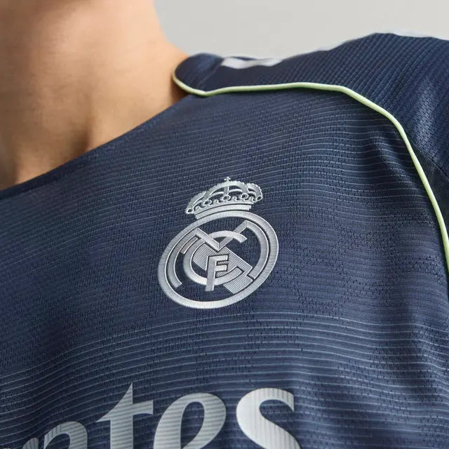 RMCFMZ0920_12 | UAE SPORT STORE Close-up of Real Madrid football jersey with the club crest on navy fabric and light green piping