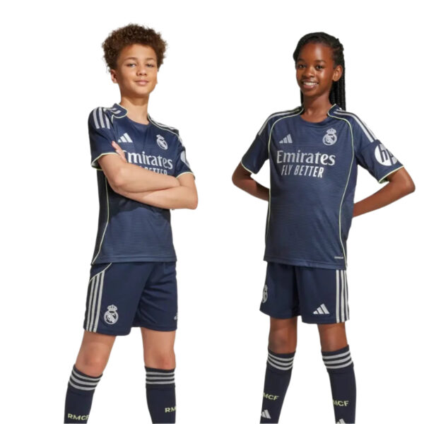 Two young soccer players—a boy and a girl—in navy Real Madrid jerseys strike confident poses with hands on hips against a white background.
