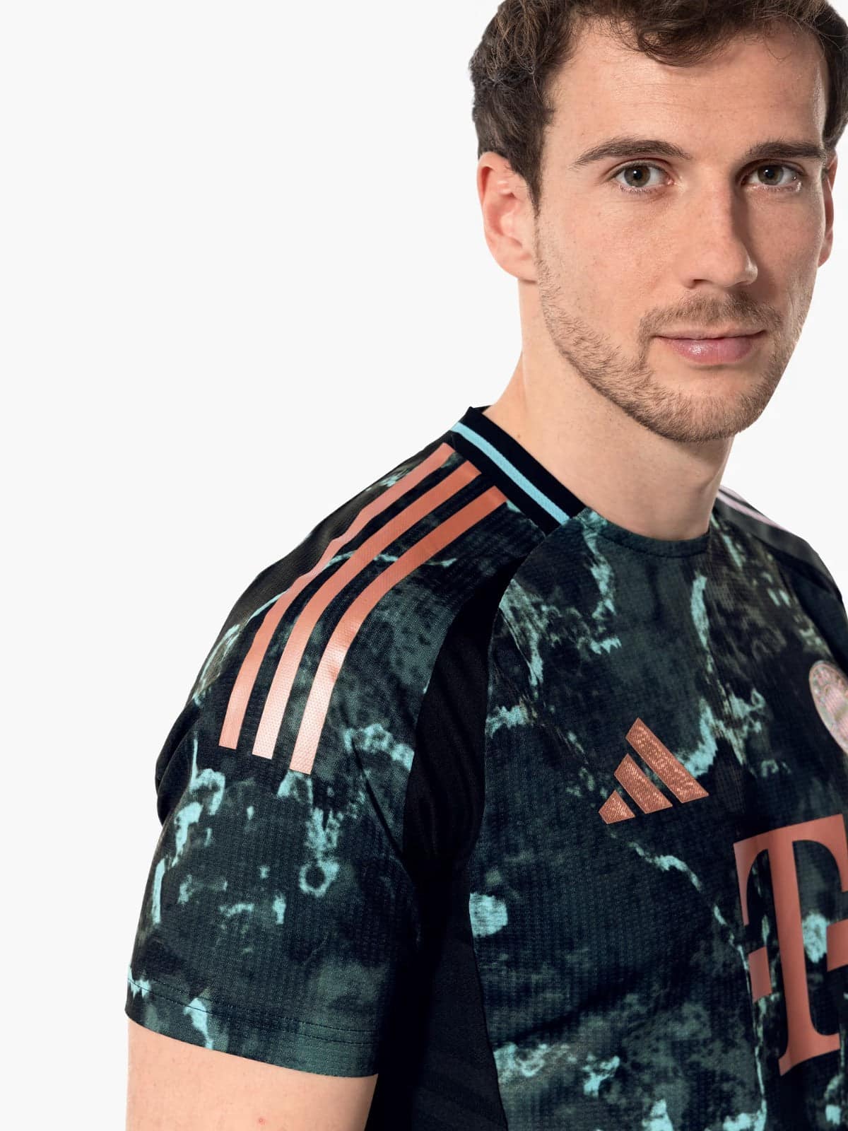 RcsXJ8Dcl5y49sV | UAE SPORT STORE Man wearing a black and teal camouflage Adidas athletic shirt with pink stripes along the shoulder, cropped at the head and torso.