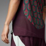 S27az9rFME6UELB | UAE SPORT STORE Close-up of a person’s arm beside a burgundy dress with teal circular pattern and a mint lining at the hem.