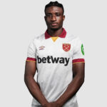 West Ham United footballer in a white away kit with a maroon collar, facing the camera.
