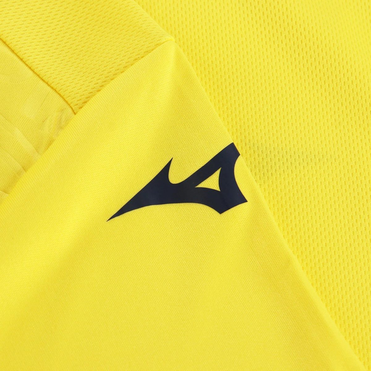 Close-up of bright yellow athletic fabric featuring a dark blue Mizuno Runbird logo on the sleeve/shoulder edge.