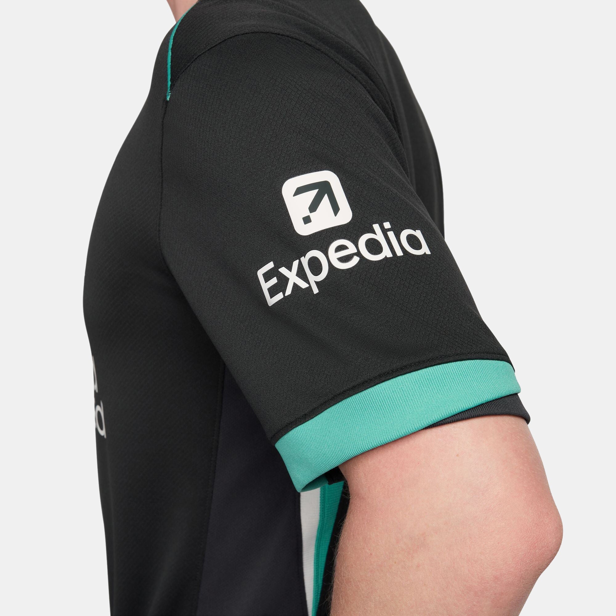 SSS2-NKFN8780_322_196976453442_5_0a11e5b6-3885-40b4-b951-6afe2a4bed96 | UAE SPORT STORE Close-up of a black sports jersey sleeve with teal cuff and a white logo on the upper arm.