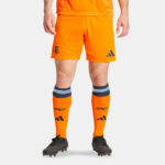 SSS2_ADIU5019_4067897379721_1 | UAE SPORT STORE Lower-body view of a footballer in bright orange shorts and matching orange socks with RMCF letters and Adidas logos, wearing dark football boots.