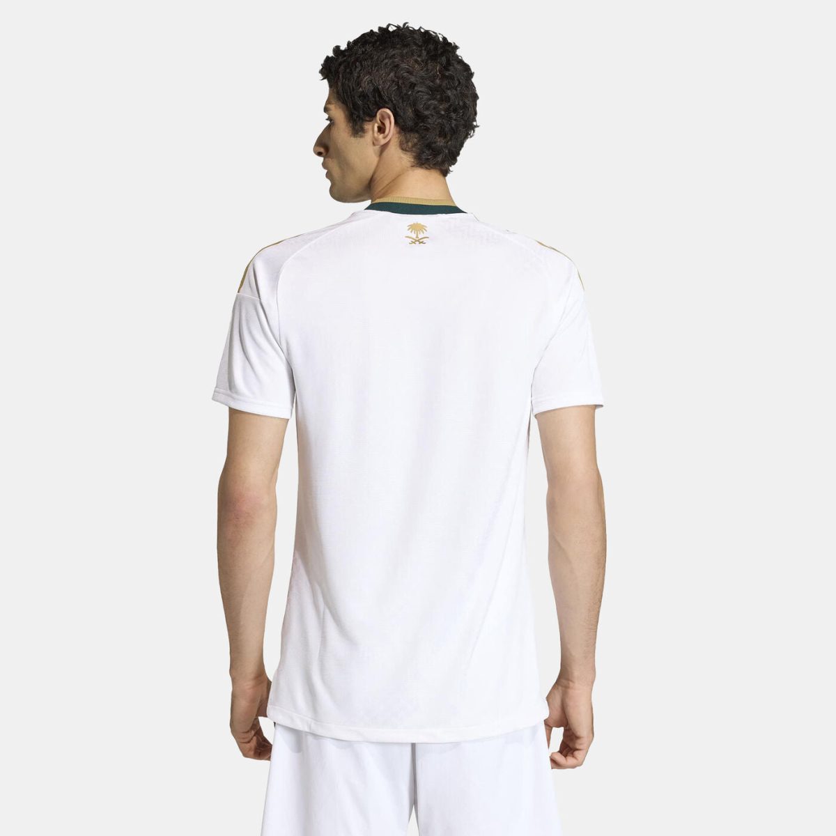 Back view of a man wearing a white polo shirt with a green-trimmed collar and a small gold palm logo on the upper back.