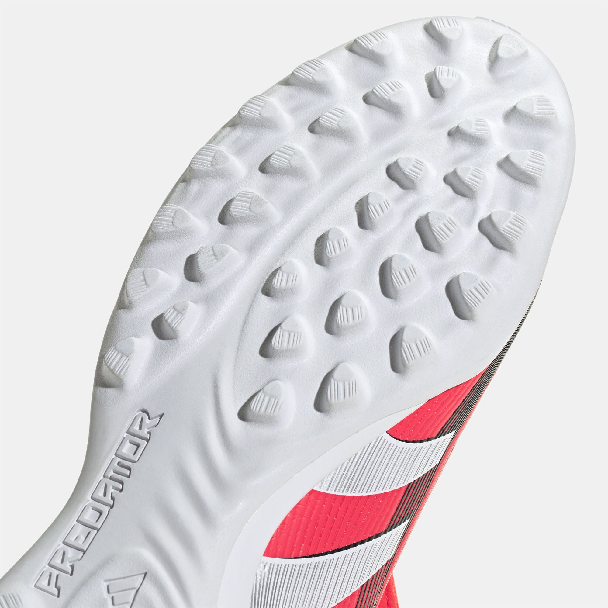 SSS2_ADJS0384_4067903835517_6 | UAE SPORT STORE Close-up of a white studded athletic shoe sole with rounded nubs and a red midsole stripe flagship edge visible on the right side.