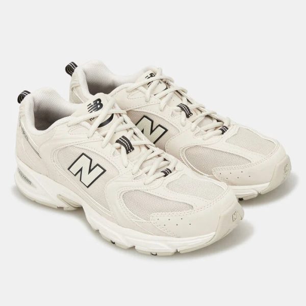 Pair of white New Balance athletic sneakers with mesh panels and black NB logos on the sides.