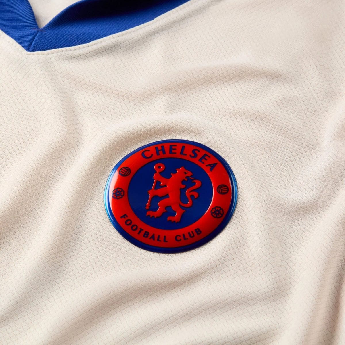 Close-up of a Chelsea Football Club circular badge on beige textured fabric.