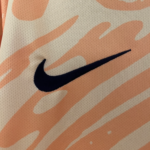 Close-up of a dark blue Nike swoosh on light orange striped fabric, likely a sports jersey