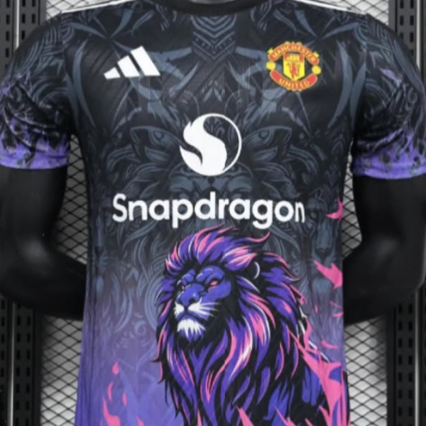 Manchester United football jersey featuring a purple-pink lion graphic and Snapdragon sponsor logo on a dark patterned shirt.