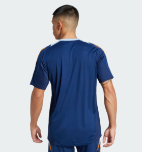 Man wearing a blue athletic jersey viewed from the back, orange trim on the shoulders, standing against a light background.