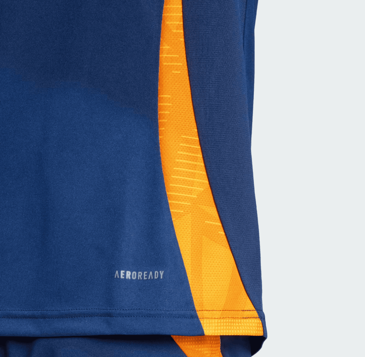 Close-up of navy blue athletic fabric with a bright orange seam/stripe and the small 'AEROREADY' branding near the hem.