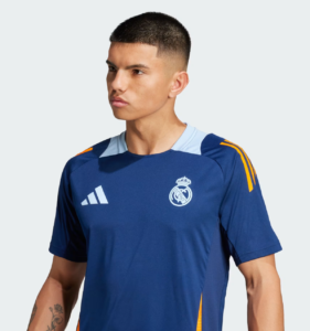 Young man wearing a blue Real Madrid training jersey with Adidas logo, looking to the left.