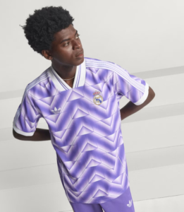 Young man wearing a purple Real Madrid jersey with a geometric pattern, looking to the left.