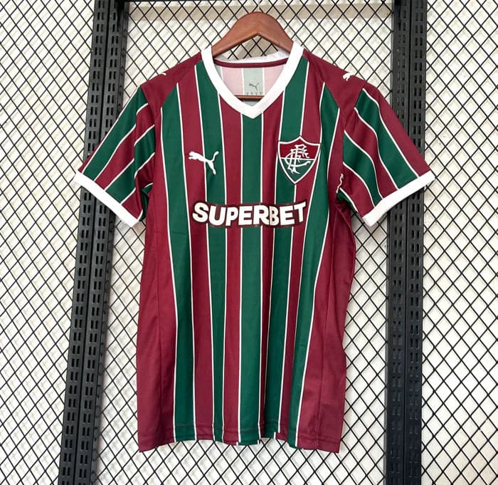 Screenshot2026-03-16at12.00.32 | UAE SPORT STORE Football jersey with maroon and green vertical stripes, white trim, hung on a wooden hanger against a mesh background, featuring a sponsor logo 'SUPERBET' and team crest on the chest.