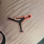 Sticker of a dark silhouette performing a high kick, with a pink outline and a ball near the foot/hand.