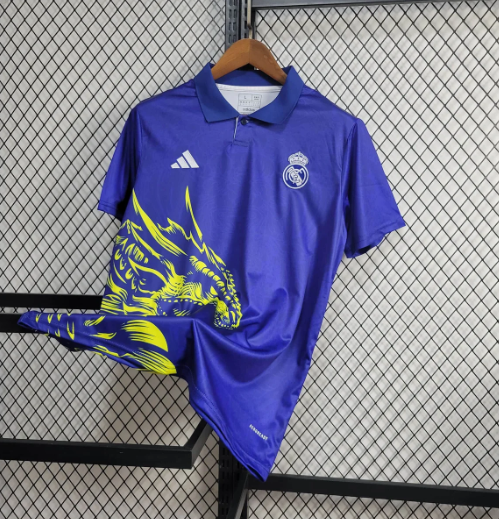 Blue polo jersey with a neon yellow dragon graphic along the front left side, featuring Adidas logo and a small crest on the chest, hanging on a rack.