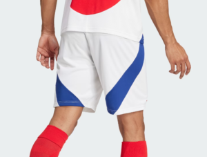 Athlete wearing white athletic shorts with blue diagonal panels and red socks, seen from the waist down.