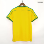 Back view of a bright yellow soccer jersey with green piping along shoulders and sleeves, on a wooden hanger