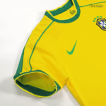 Close-up of a yellow Brazil national football team jersey sleeve with green trim, Nike swoosh, and CBF crest.