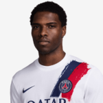 Close-up portrait of a man wearing a white Paris Saint-Germain football jersey with a blue and red brushstroke design and club crest visible on the chest.